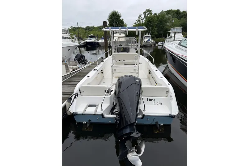 Slide: The Image of 2001 Boston Whaler 21 Outrage boat docked, rear view with outboard motor. - 5