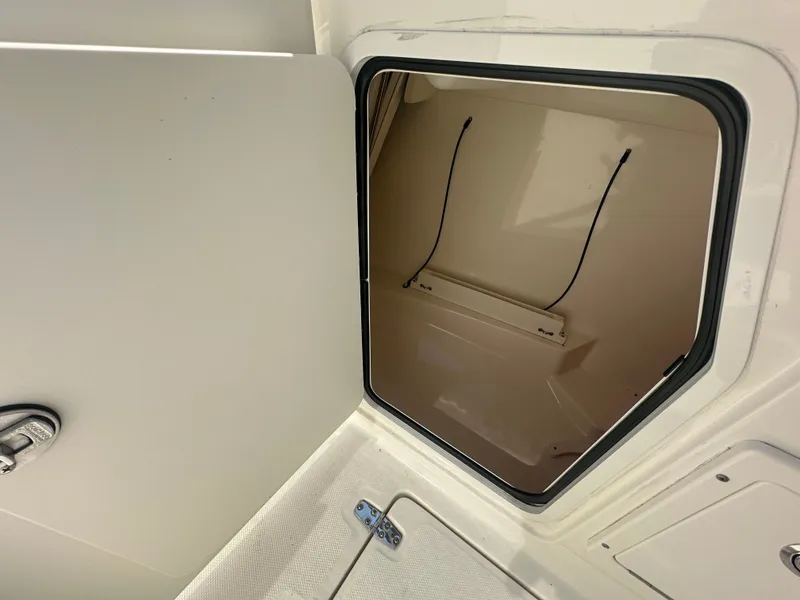 Slide: The Image of An open storage compartment on a 2018 Boston Whaler 230 Vantage boat, featuring a clean beige interior. - 16
