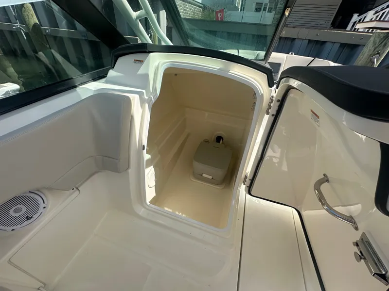 Slide: The Image of The image shows the interior of a 2018 Boston Whaler 230 Vantage with a small toilet. - 15