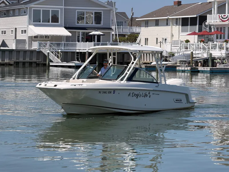Slide: The Image of A 2018 Boston Whaler 230 Vantage cruising on calm water near a residential area. - 28