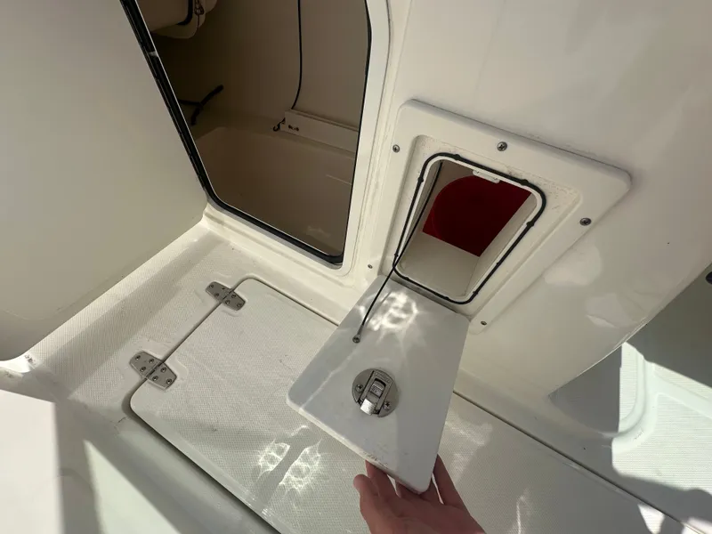 Slide: The Image of An open storage compartment on a boat with a small door and hinged lid. - 17