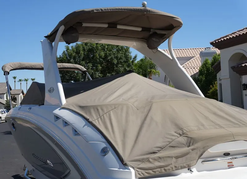 Slide: The Image of A 2008 Chaparral 264 Sunesta boat with a cover, parked in a residential area. - 36