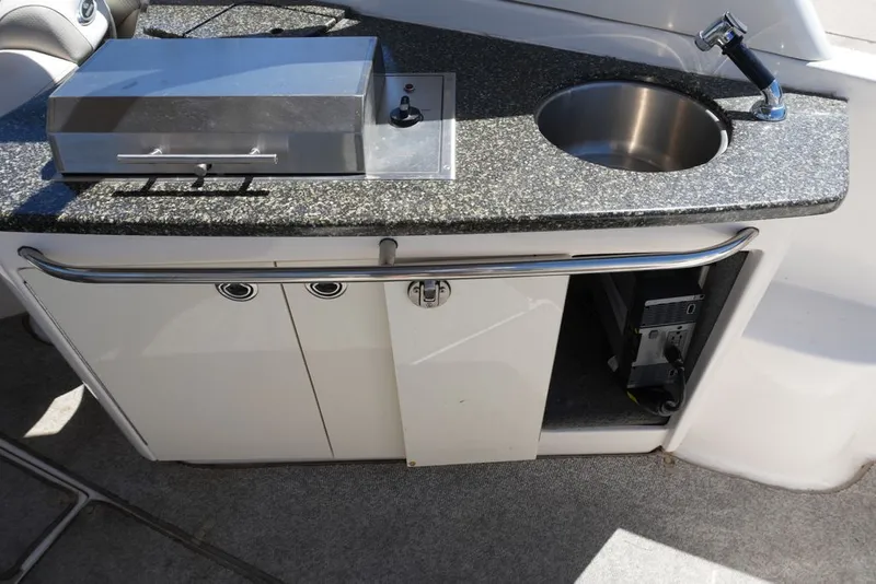 Slide: The Image of The 2008 Chaparral 264 Sunesta features an onboard kitchenette with a sink and grill. - 9