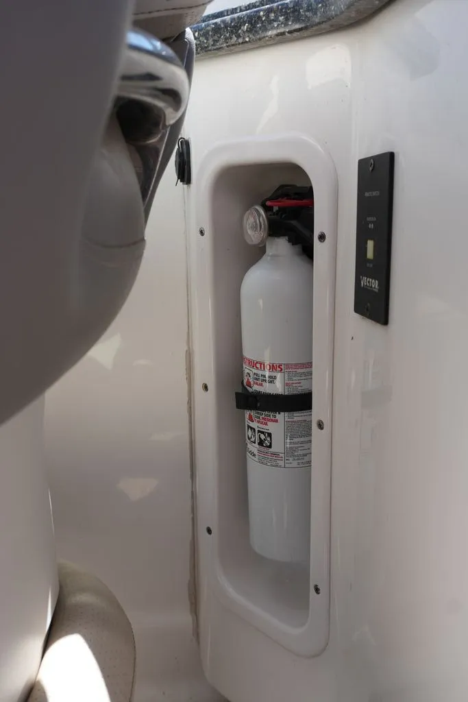 Slide: The Image of A fire extinguisher is mounted in a white compartment on a boat. - 11