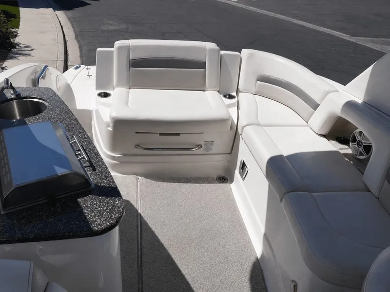 Slide: The Image of The image shows the cockpit of a 2008 Chaparral 264 Sunesta with white seating and a small kitchenette. - 19