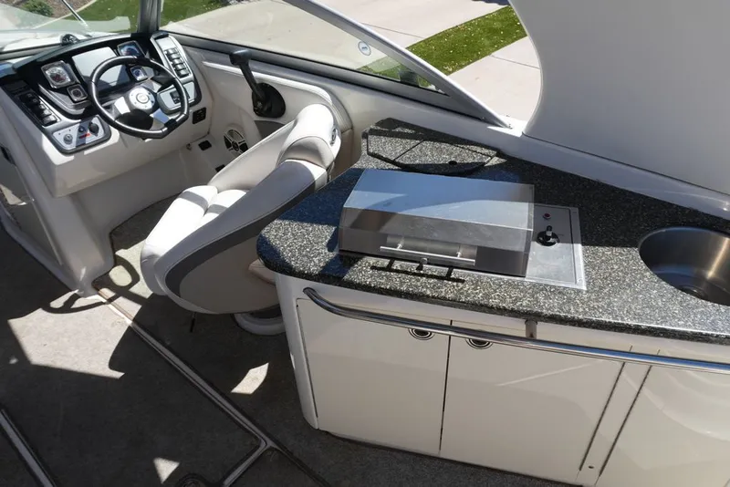 Slide: The Image of The image shows the cockpit of a 2008 Chaparral 264 Sunesta with helm and kitchenette. - 8