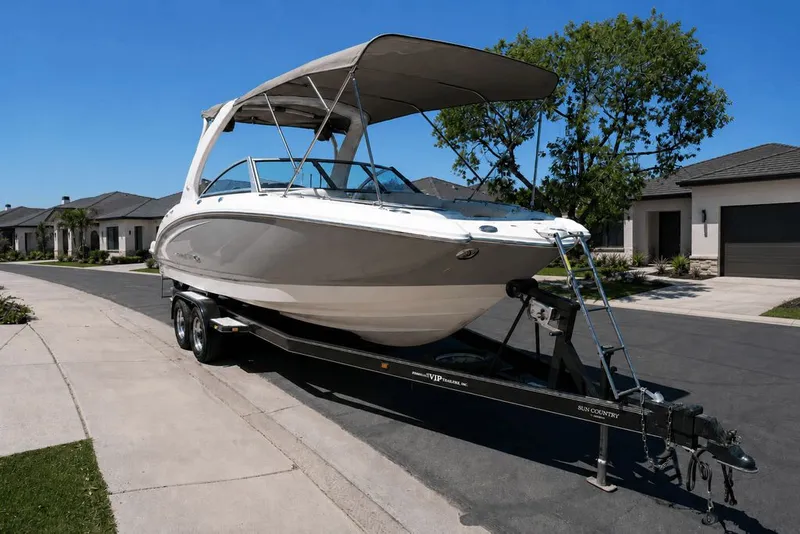 Slide: The Image of A 2008 Chaparral 264 Sunesta on a trailer in a residential area, featuring a large sunshade. - 37