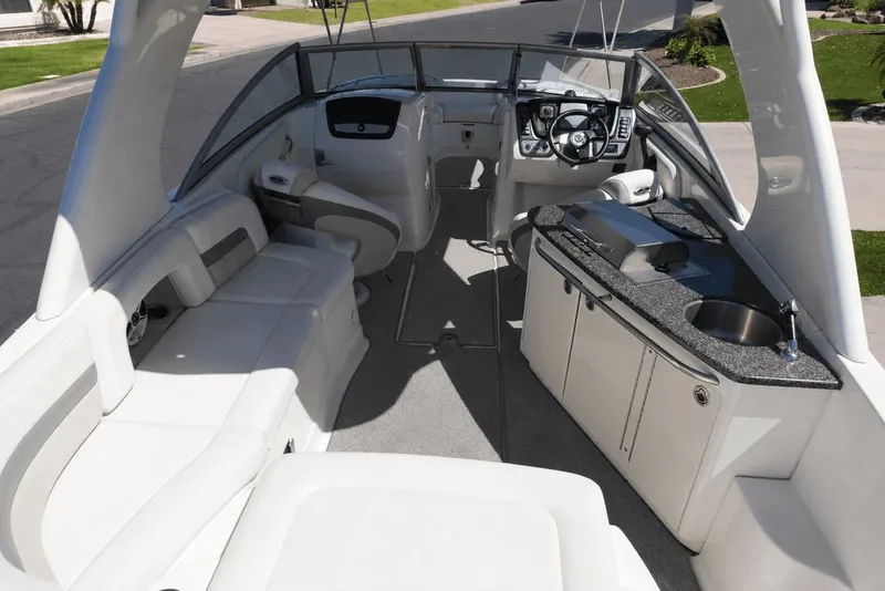 Slide: The Image of The image shows the cockpit of a 2008 Chaparral 264 Sunesta with white seating and a kitchenette. - 15