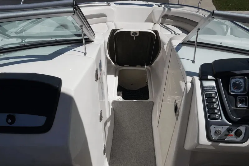 Slide: The Image of The image shows the cockpit of a 2008 Chaparral 264 Sunesta boat with a helm console and storage area. - 12