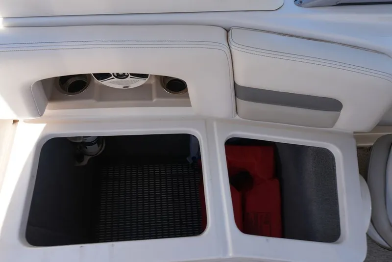Slide: The Image of The image shows the storage area of a 2008 Chaparral 264 Sunesta boat with two open compartments. - 25