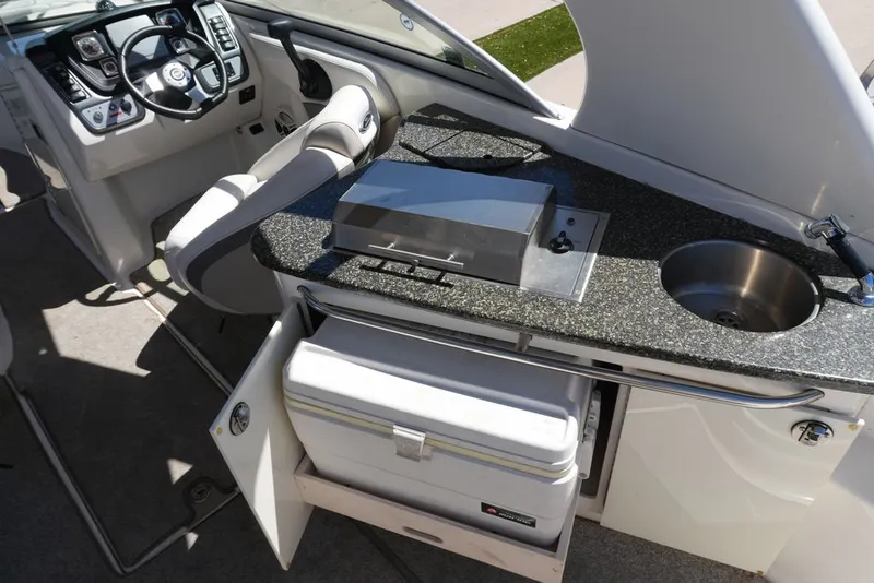 Slide: The Image of The image shows the cockpit of a 2008 Chaparral 264 Sunesta with helm and kitchenette. - 7
