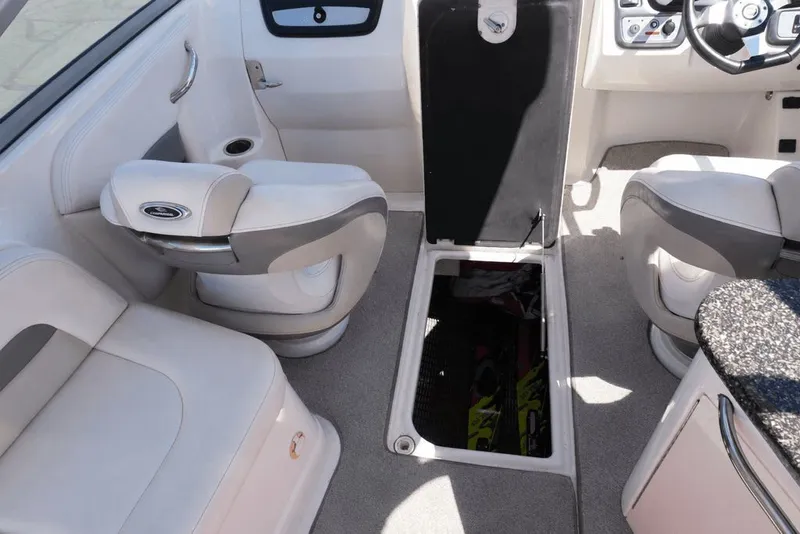Slide: The Image of The image shows the interior of a 2008 Chaparral 264 Sunesta boat with white seating and storage. - 13
