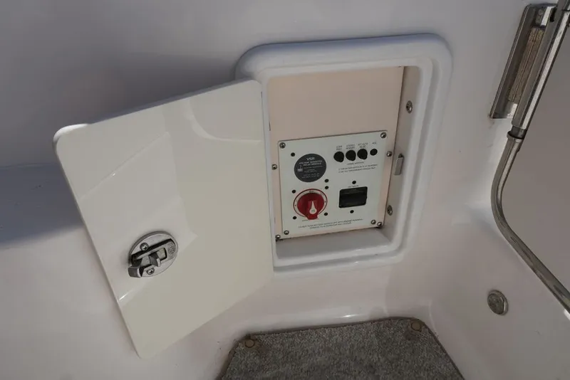 Slide: The Image of An open control panel with switches and a rotary knob inside a boat. - 26