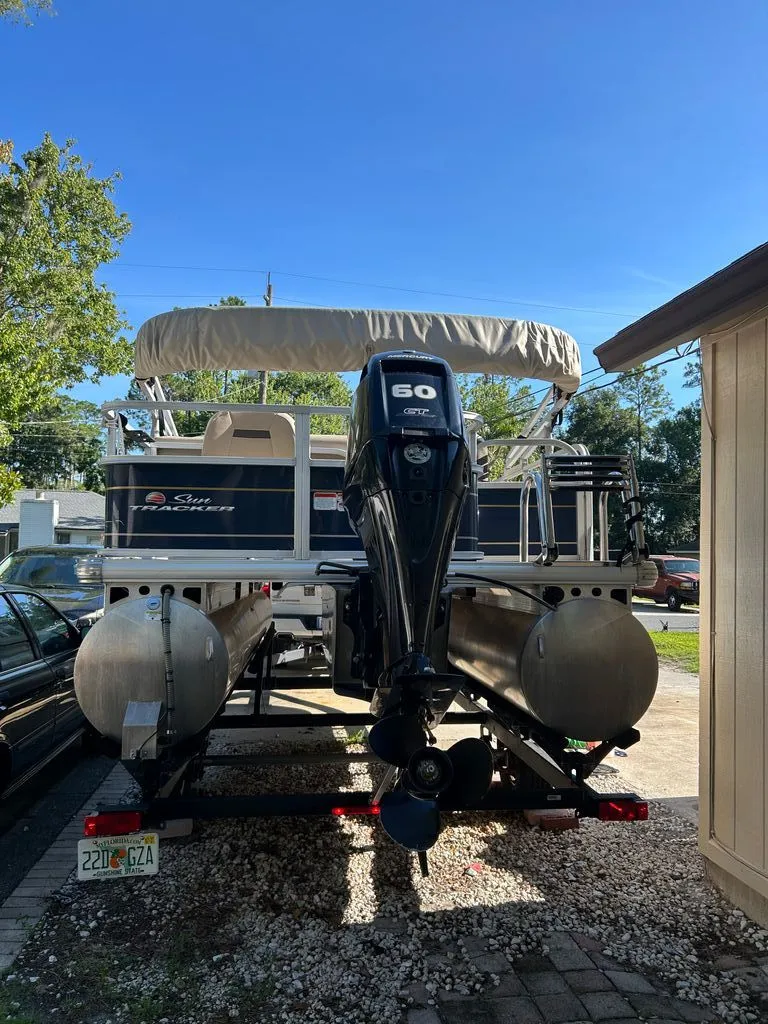 Slide: The Image of A 2023 Sun Tracker Bass Buggy pontoon boat with a 60 HP motor, parked on a trailer. - 19