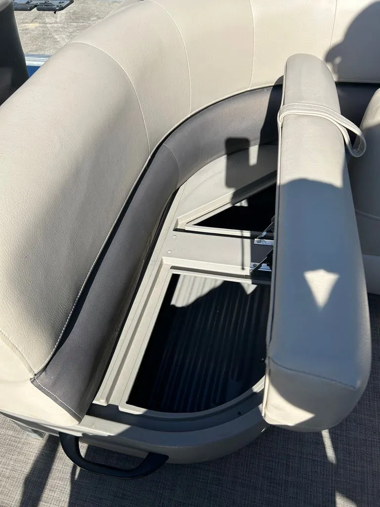 Slide: The Image of A seating area on a 2023 Sun Tracker Bass Buggy with a lifted seat revealing storage underneath. - 10