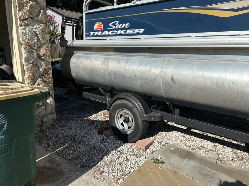 Slide: The Image of A 2023 Sun Tracker Bass Buggy is parked on a trailer in a yard. - 16