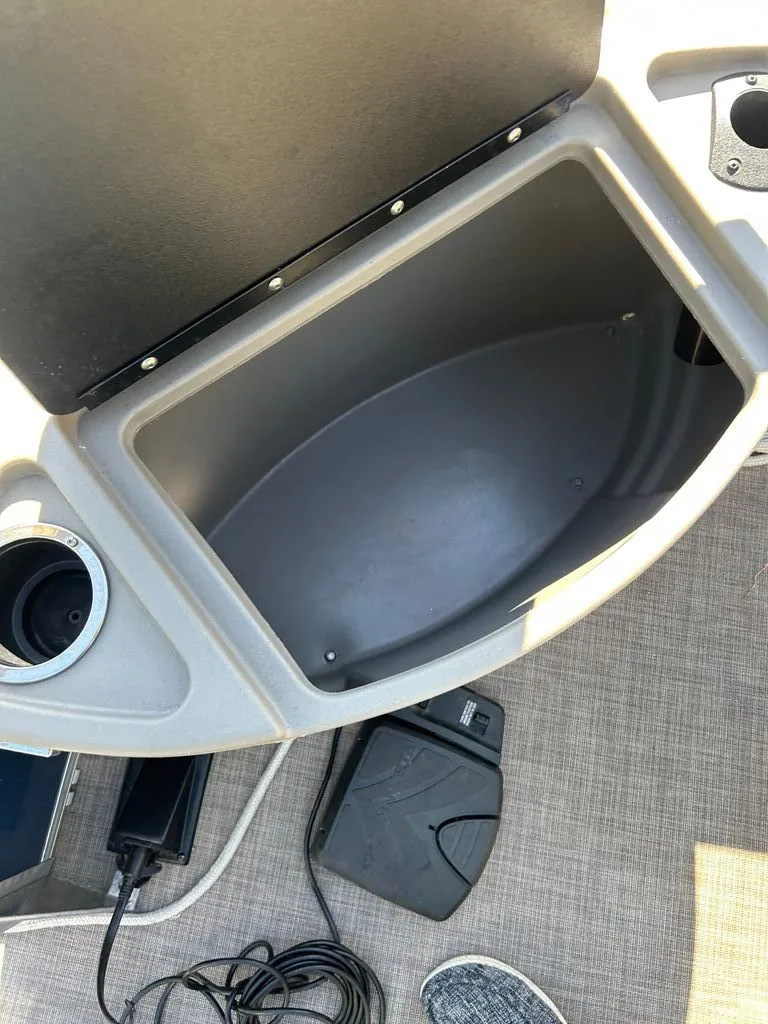 Slide: The Image of An open storage compartment on a 2023 Sun Tracker Bass Buggy with a gray interior. - 12