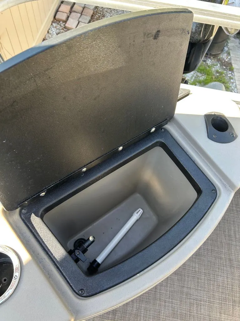 Slide: The Image of An open storage compartment on a 2023 Sun Tracker Bass Buggy with a white rod inside. - 11