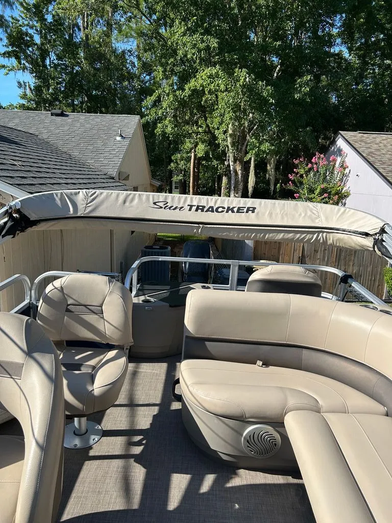 Slide: The Image of 2023 Sun Tracker Bass Buggy with beige seating and sunshade, parked in a residential area. - 7