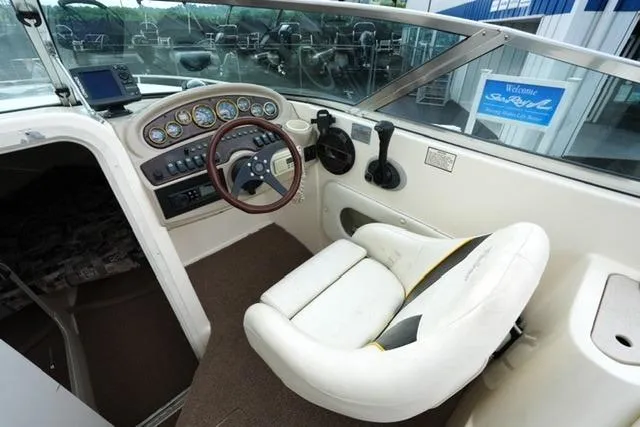 Slide: The Image of 2002 Rinker 276 Captiva Cuddy boat cockpit with steering wheel and control panel. - 10