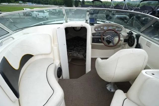 Slide: The Image of 2002 Rinker 276 Captiva Cuddy boat interior with steering wheel and seating area. - 9