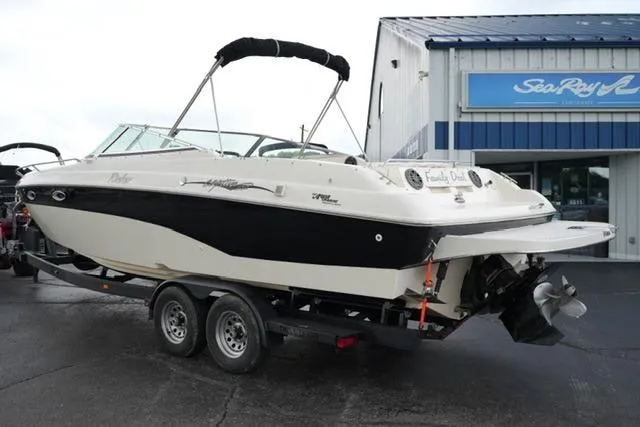 Slide: The Image of 2002 Rinker 276 Captiva Cuddy boat on trailer, parked outside a marine dealership. - 7