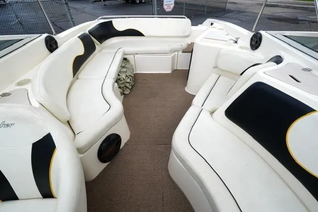 Slide: The Image of 2002 Rinker 276 Captiva Cuddy boat interior with white seating and black accents. - 12