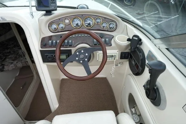 Slide: The Image of 2002 Rinker 276 Captiva Cuddy boat dashboard with steering wheel and control panel. - 11
