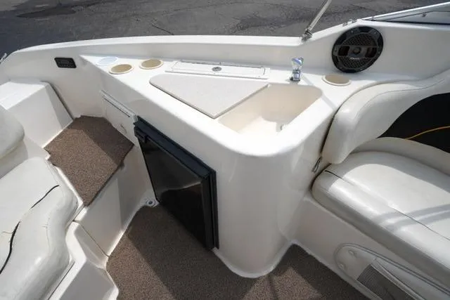 Slide: The Image of 2002 Rinker 276 Captiva Cuddy interior with sink, cup holders, and seating. - 16