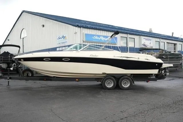 The Image of 2002 Rinker 276 Captiva Cuddy boat on trailer outside dealership. - 1