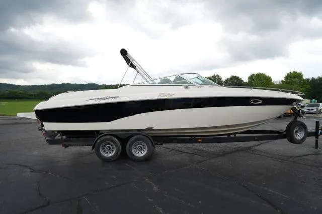 Slide: The Image of 2002 Rinker 276 Captiva Cuddy boat on trailer, parked outdoors under cloudy sky. - 4