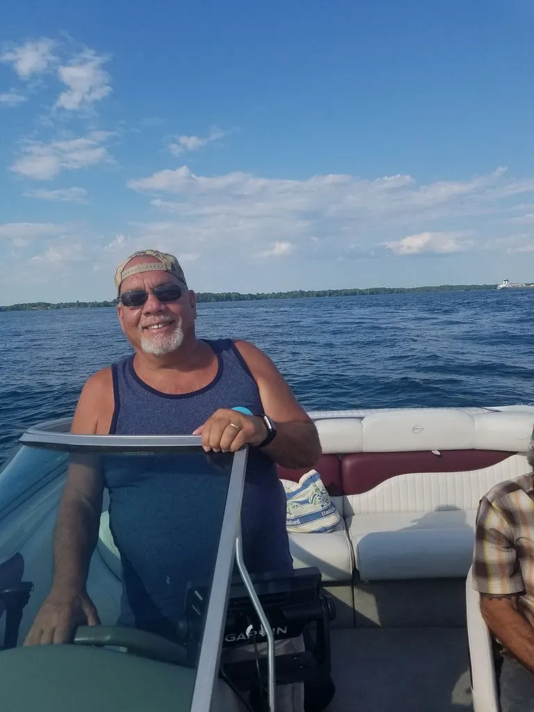 Slide: The Image of A man stands at the helm of a Crownline 192 BR boat on a lake. - 2