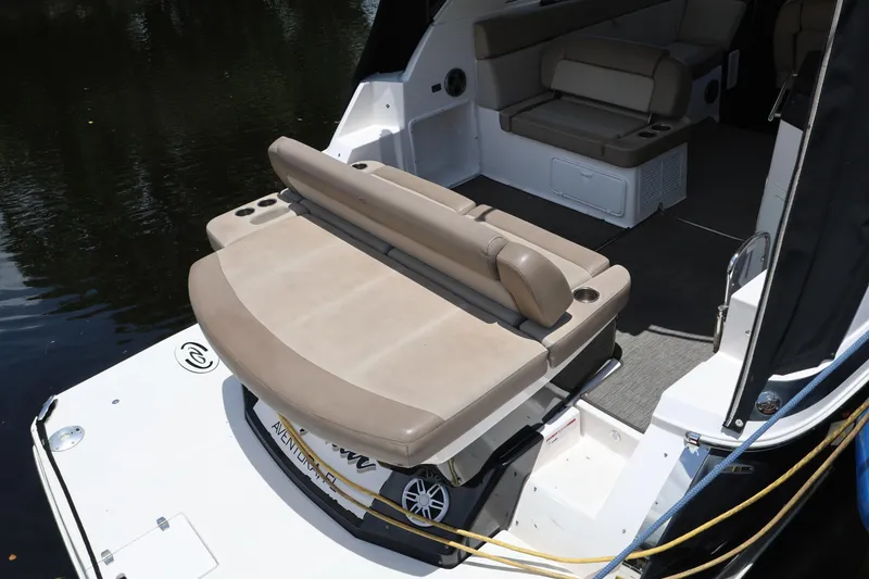 Slide: The Image of 2015 Regal 35 Sport Coupe boat interior with beige seating and spacious deck area. - 4