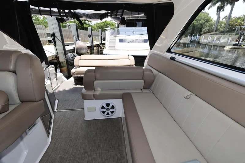 Slide: The Image of Interior of 2015 Regal 35 Sport Coupe boat with beige seating and waterfront view. - 13