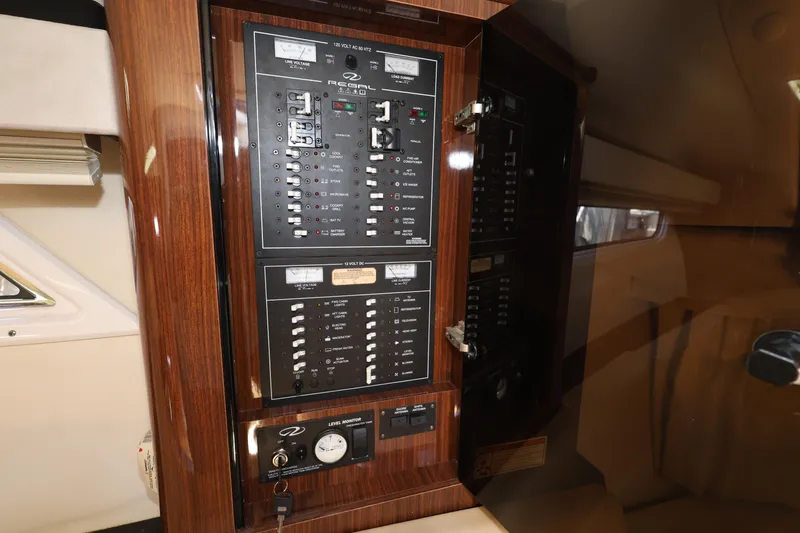 Slide: The Image of Control panel inside a 2015 Regal 35 Sport Coupe yacht, featuring various switches and gauges. - 21