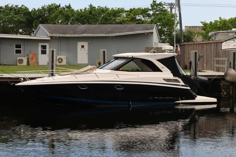 Slide: The Image of 2015 Regal 35 Sport Coupe docked at marina, sleek design, calm water reflection. - 2
