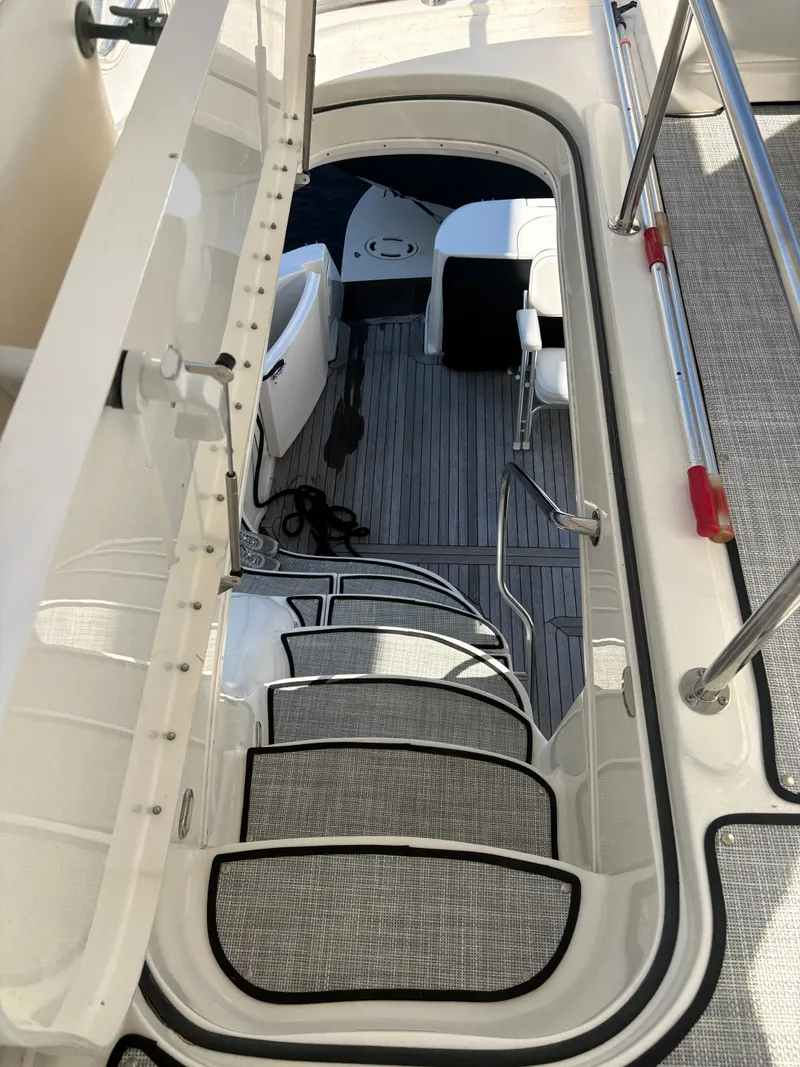 Slide: The Image of A staircase leads from the flybridge to a lower deck with gray flooring and white seating. - 16