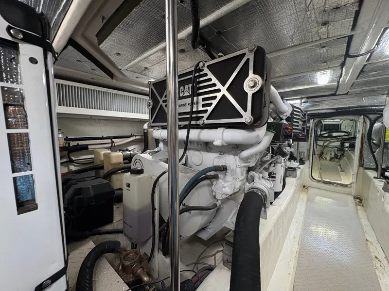Slide: The Image of The engine room of a 2000 Sea Ray 560 Sedan Bridge features a large engine and piping. - 47
