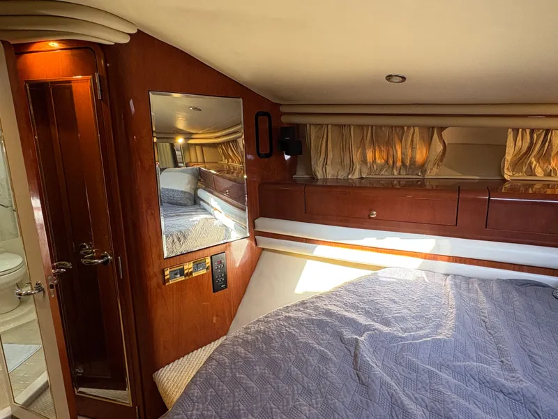 Slide: The Image of The cabin of a 2000 Sea Ray 560 Sedan Bridge with a bed and wood paneling. - 20