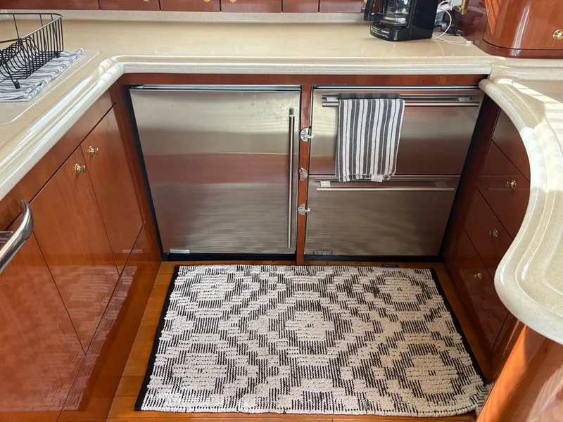 Slide: The Image of The galley of a 2000 Sea Ray 560 Sedan Bridge with wood cabinets and stainless steel appliances. - 33