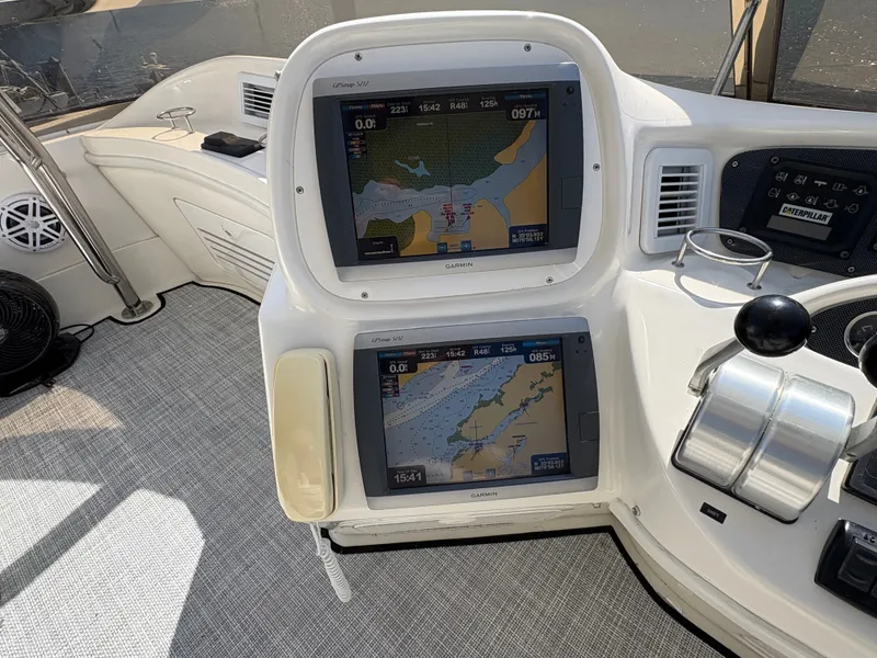 Slide: The Image of The image shows the helm of a 2000 Sea Ray 560 Sedan Bridge with two navigation screens. - 7