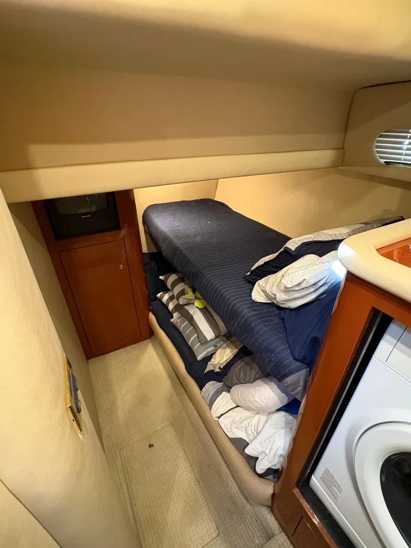 Slide: The Image of Cabin with bunk bed and washing machine in a 2000 Sea Ray 560 Sedan Bridge. - 28