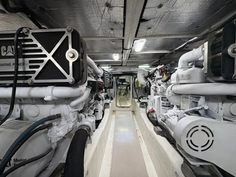 Slide: The Image of The engine room of a 2000 Sea Ray 560 Sedan Bridge features two large engines and piping. - 45