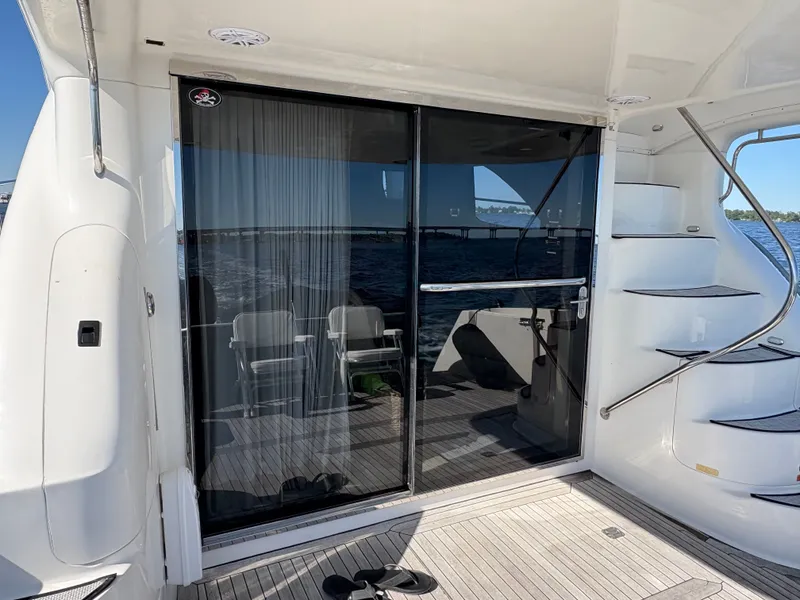 Slide: The Image of The 2000 Sea Ray 560 Sedan Bridge features an elegant aft deck with glass doors and stairs. - 15