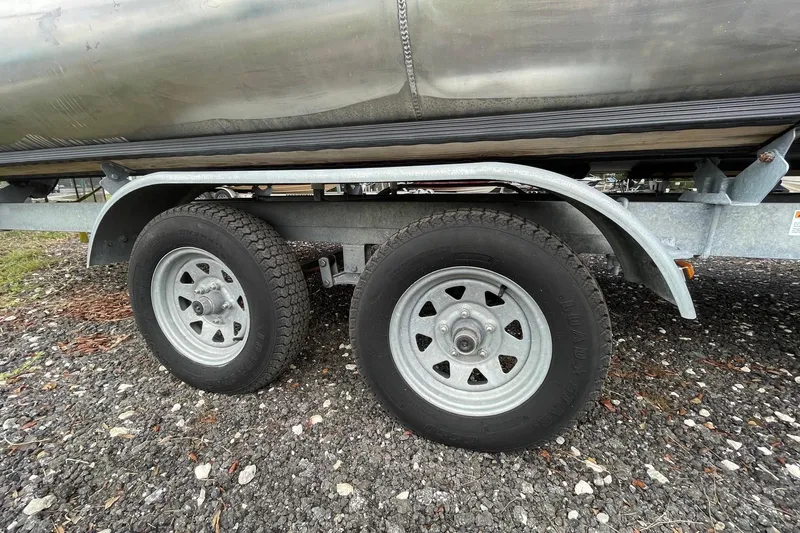 Slide: The Image of Trailer wheels of a 2021 Bentley Pontoons 240 CRUISE on gravel surface. - 9