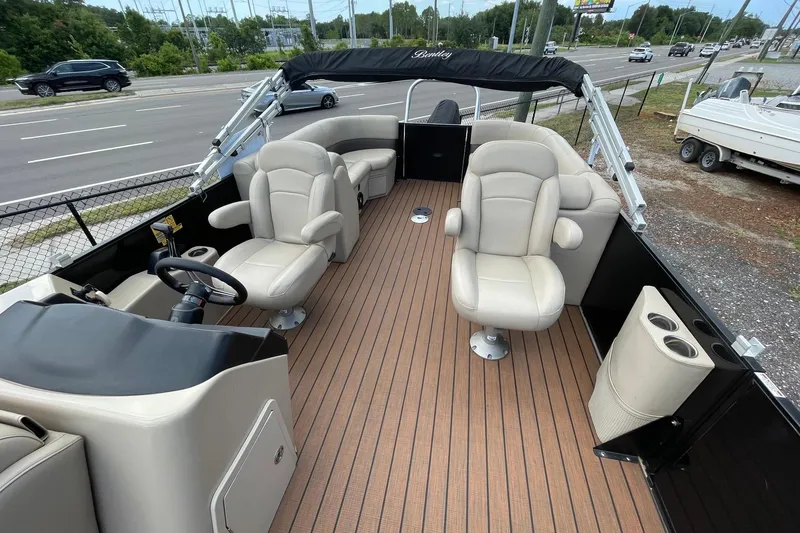 Slide: The Image of 2021 Bentley Pontoons 240 CRUISE interior with plush seating and modern helm on a wooden deck. - 6