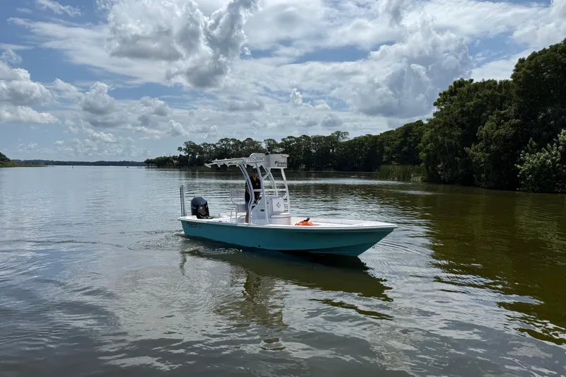 Slide: The Image of 2024 Piranha Boatworks Casador B2250 on a serene lake under a cloudy sky. - 27