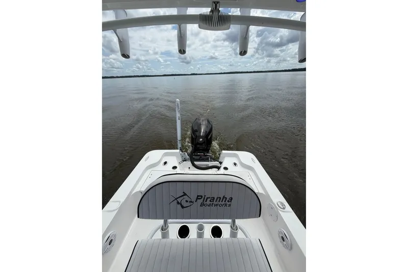 Slide: The Image of 2024 Piranha Boatworks Casador B2250 on calm waters, showcasing rear seating and motor. - 37