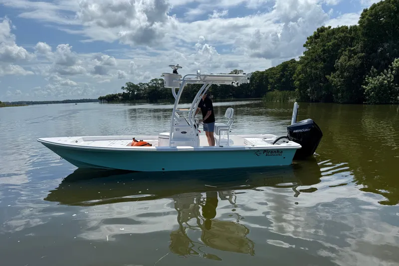 Slide: The Image of 2024 Piranha Boatworks Casador B2250 on calm lake under cloudy sky. - 19