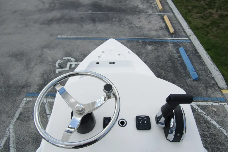 Slide: The Image of 2024 Piranha Boatworks Casador B2250 helm with steering wheel and controls in parking lot. - 12